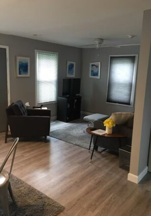 A living room with a sofa, a coffee table, and a television.