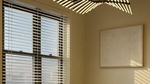 Uma área de refeições moderna com mesa, cadeiras e um lustre único.