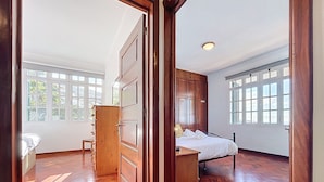 Un dormitorio amplio con una cama grande, armario de madera y un escritorio.