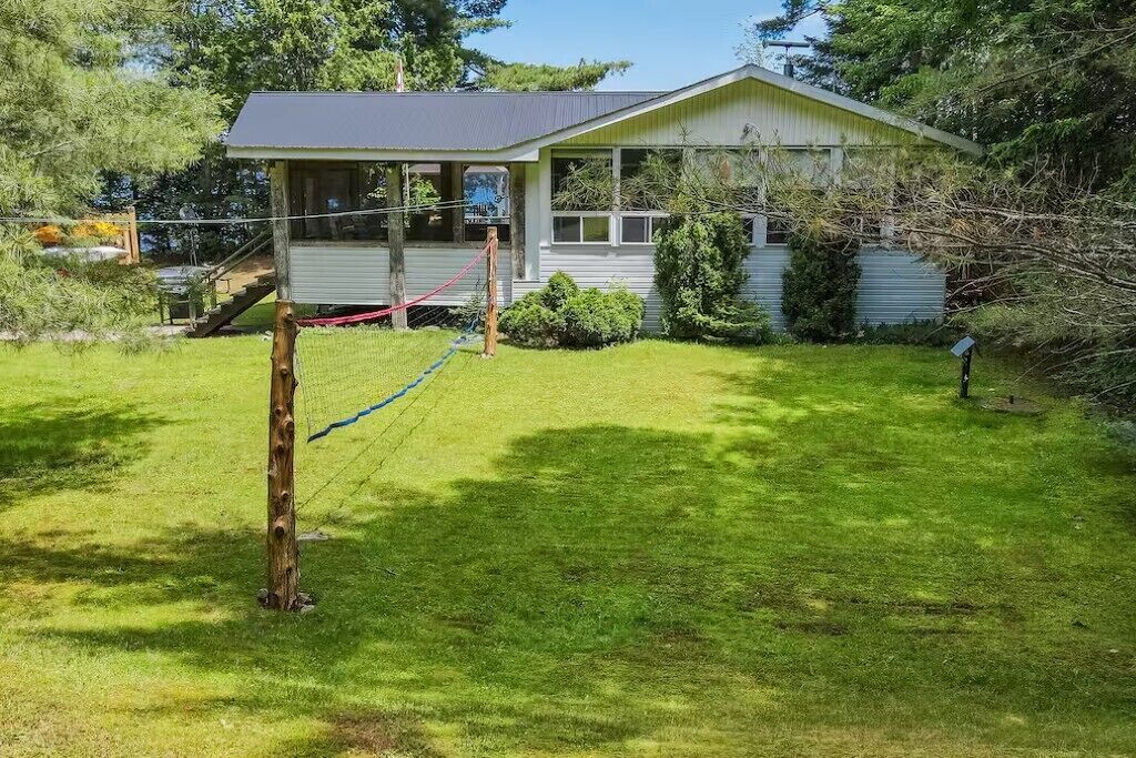 A house with a covered porch, a fenced yard, and a small garden area.