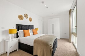 Een slaapkamer met een bed, nachtkastjes, een kledingkast en een raam.