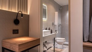 Et moderne badeværelse med brusebad, toilet og håndvask.