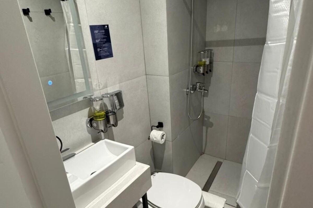 A modern bathroom with a toilet, sink, and shower.