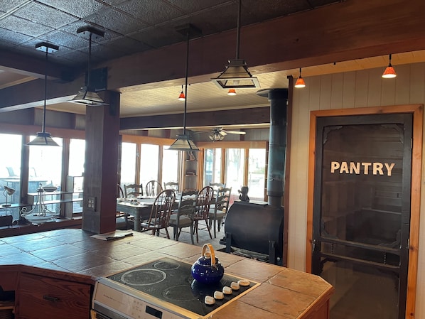 L’intérieur d’un restaurant, avec un comptoir de cuisine, une salle à manger et une porte donnant sur le garde-manger.