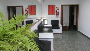 A hotel lobby with a reception desk, seating area, and a staircase leading to another floor. - Hotel Mar de Ajo (Mar de Ajo)