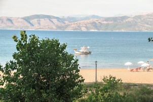 Una playa con un bote, sombrillas y un farol.