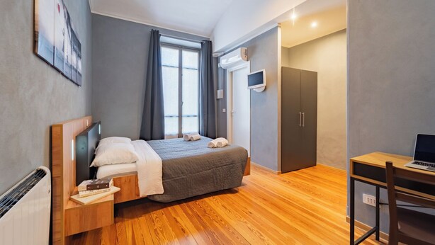 Una camera da letto moderna con un letto, una scrivania e un armadio.