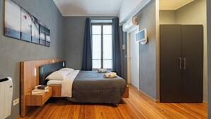 Una camera da letto moderna con un letto di legno, un comodino, un armadio e un'ampia finestra con tende.