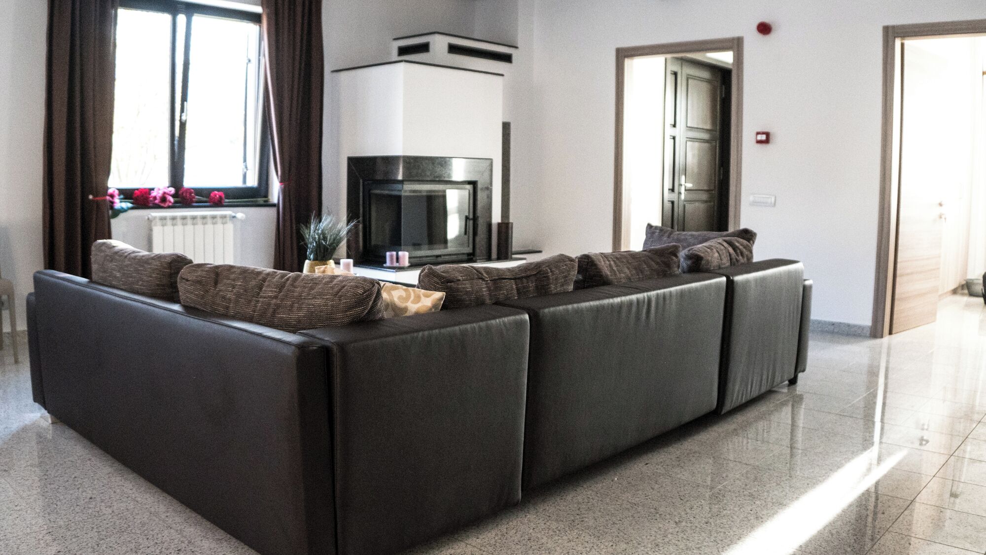 A modern living room with a sectional sofa, a fireplace, and a television.