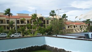 A hotel with multiple balconies, a swimming pool, and palm trees. - El Mirador (Los Cristianos)