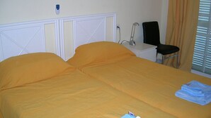 A double bed with a white headboard, a bedside table with a lamp, and a chair. - El Mirador (Los Cristianos)