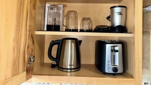 Ein Holzkorpus mit Kaffeemaschine, Mixer, Wasserkocher und Toaster.