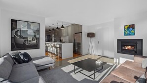 A modern living room with a grey sofa, a black coffee table, and a fireplace. - Lakeside Retreat - Cromwell Holiday Home (Cromwell)
