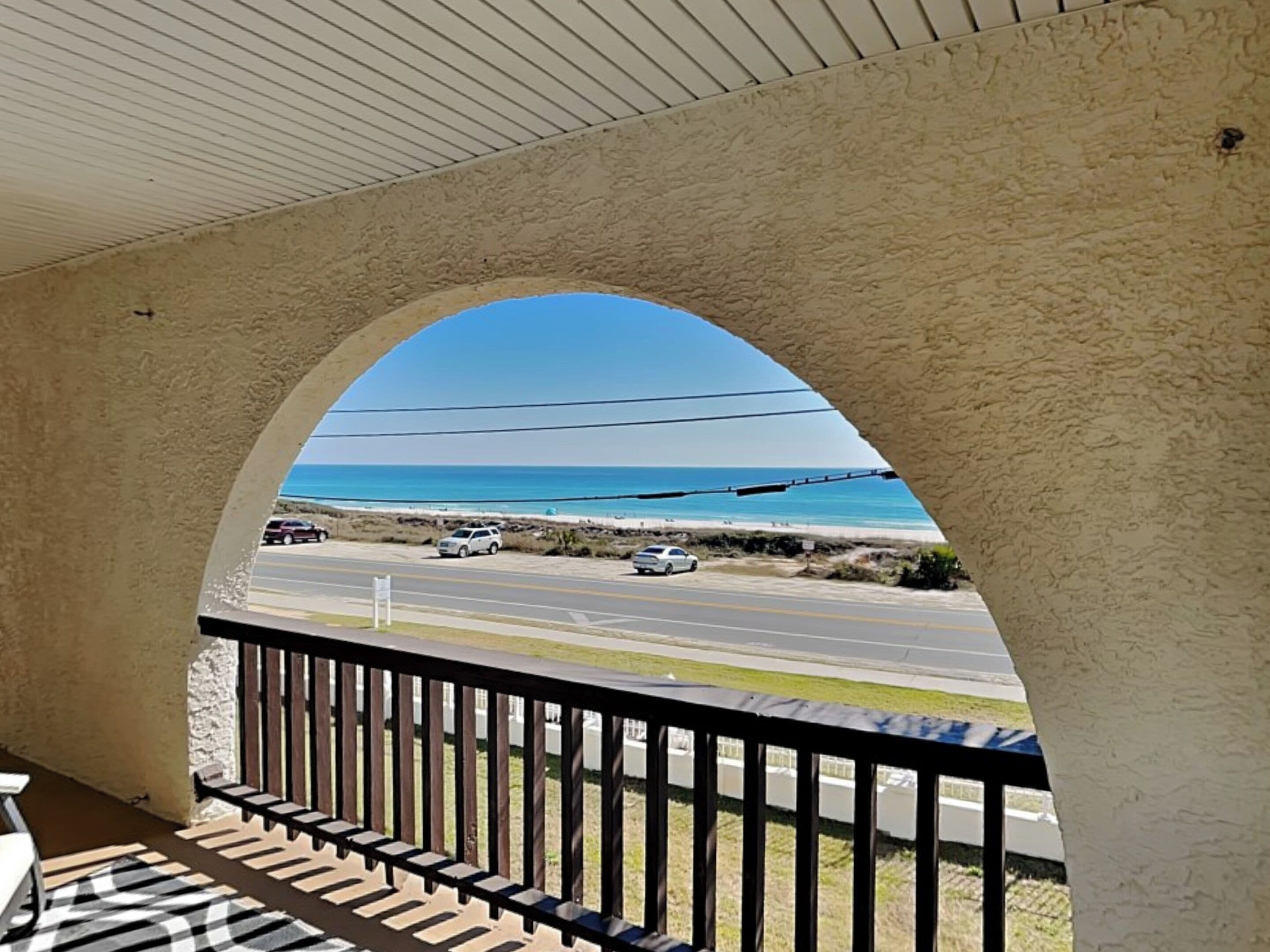Een balkon met uitzicht op een strand en een weg.