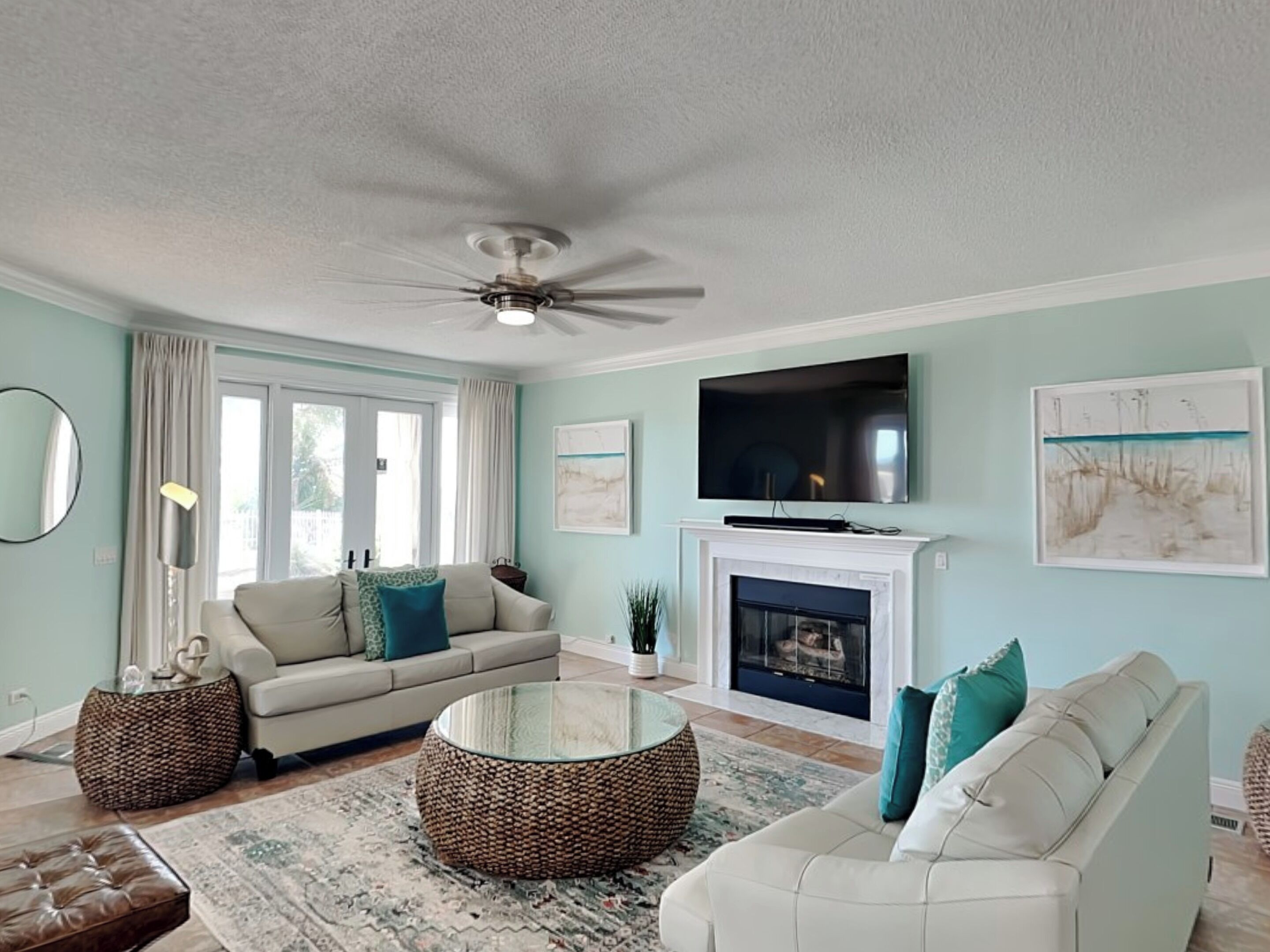A living room with a sofa, coffee table, fireplace, and television.