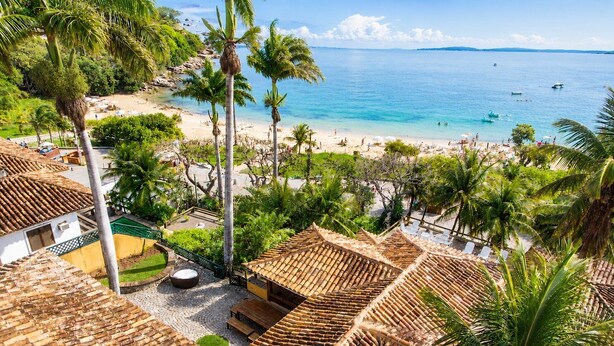 A tropical resort with bamboo roofs, palm trees, and a beach view. - Bz81 Pé na areia na Praia da Ferradura (Buzios)