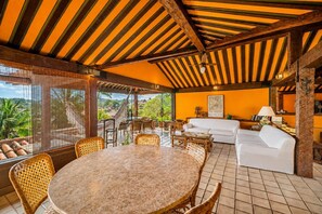 Une pièce avec une table ronde, des chaises, un canapé et un ventilateur de plafond.