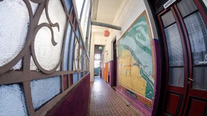 A corridor with patterned walls, a tiled floor, and a door labeled "DEPOSITO". - La Comunidad Hostel (Rosario)