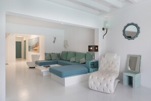 A modern living room with a sectional sofa, a white armchair, and a small side table with a lamp. - Vacation Villa 'Lunamoon' with Private Pool, Wi-Fi and Air Conditioning (Unknown)