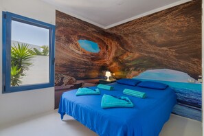 A bedroom with a bed, a window, and a mural of a cave. - Vacation Villa 'Lunamoon' with Private Pool, Wi-Fi and Air Conditioning (Unknown)