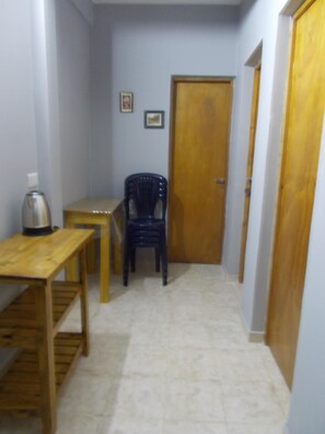 A small room with a wooden table, a chair, a door, and a wall-mounted picture. - Hotel Brisas (San Clemente)