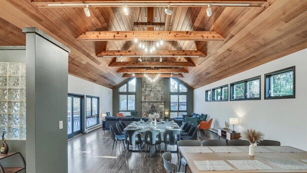 A spacious dining area with a high ceiling, wooden beams, and large windows. - 7BR Monroe Getaway: Pool, Hot Tub, & Huge Living Space (Monroe)
