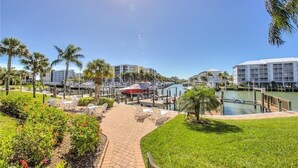 A resort with a marina, palm trees, and a clear blue sky. - Charming Canal View 1-bedroom condo in fabulous Fort Myers Beach (Fort Myers Beach)