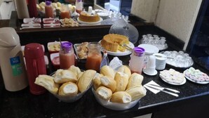 A buffet with various food items, including bread, desserts, and beverages. - Hotel Flert Santana (Sao Paulo)