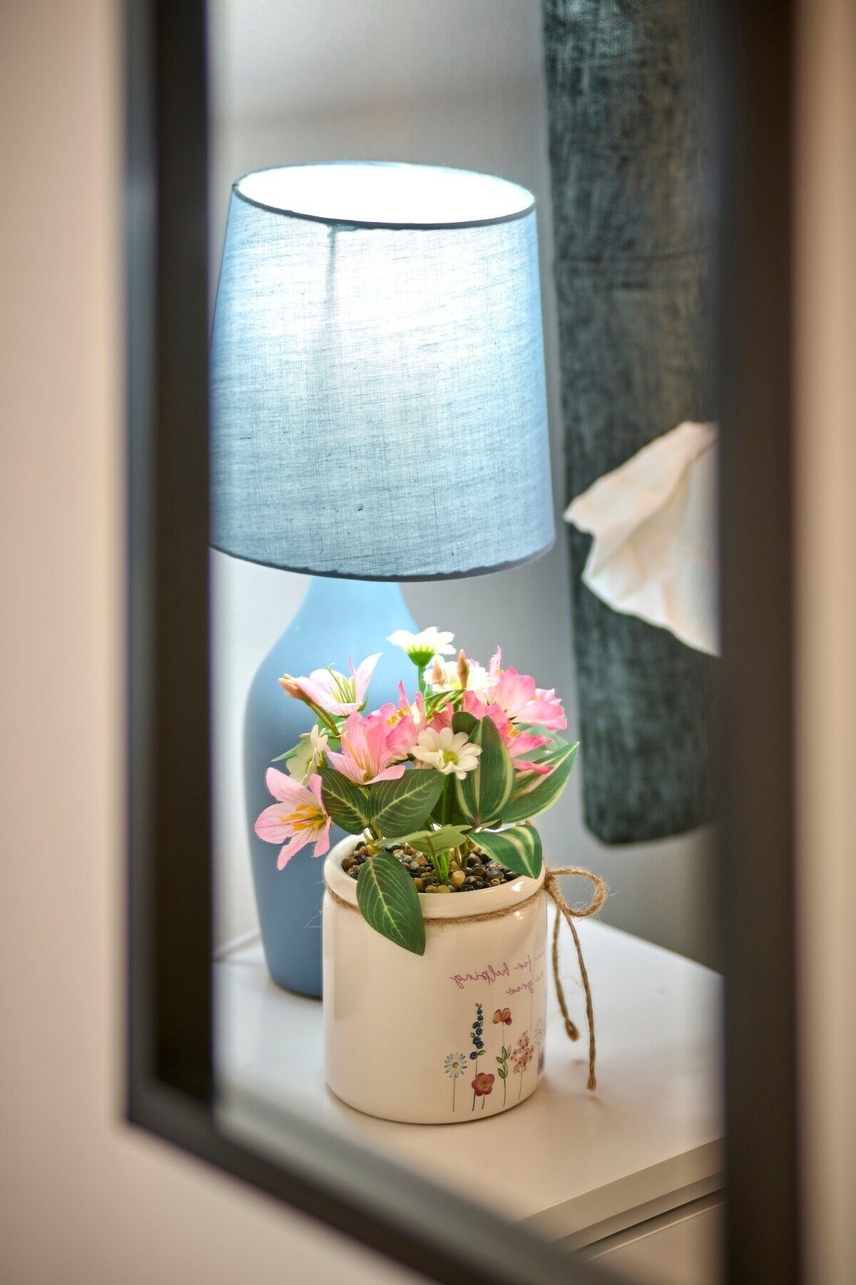 A window with a lamp and a potted plant on a windowsill.