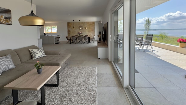 A modern living room with a sofa, coffee table, and dining area.