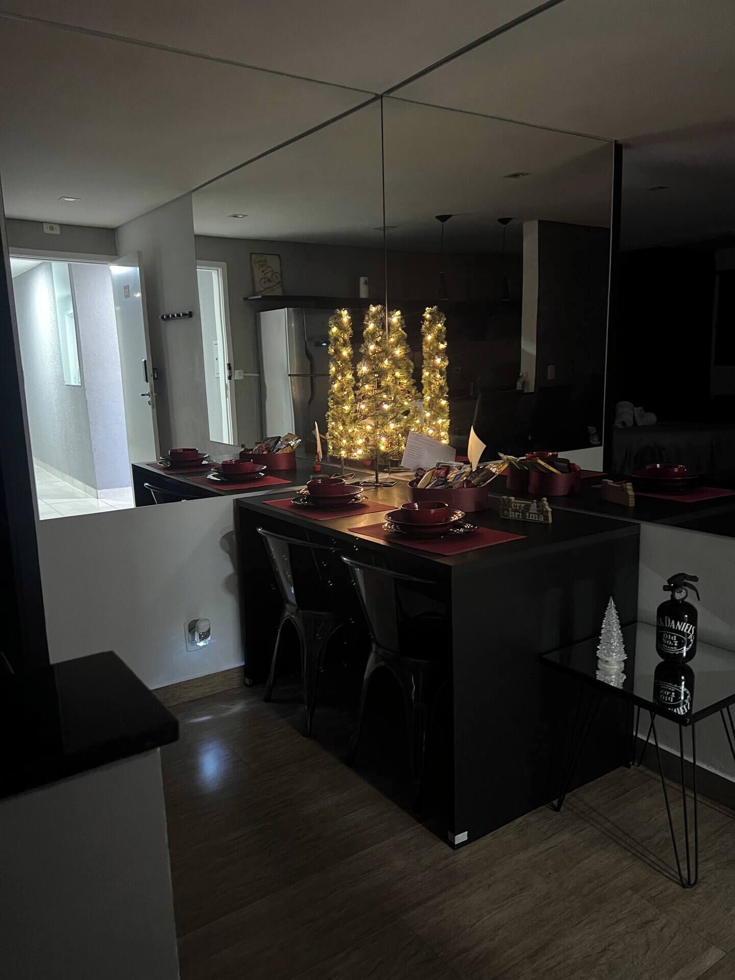 A modern kitchen with a central island, a refrigerator, and a Christmas tree.