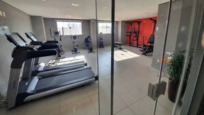 Academia com esteiras, bicicletas ergométricas e equipamentos de musculação.