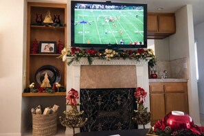 A living room with a television, fireplace, and Christmas decorations. - Escape to Paradise 3 bed-3 bath- Private Pool and Hot Tub Cooling Misting System (Palm Desert)
