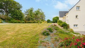 A residential area with a grassy lawn, a pathway, and a building with a sloped roof.