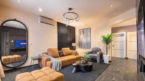 A modern living room with a sofa set, a coffee table, a TV, and a large mirror.