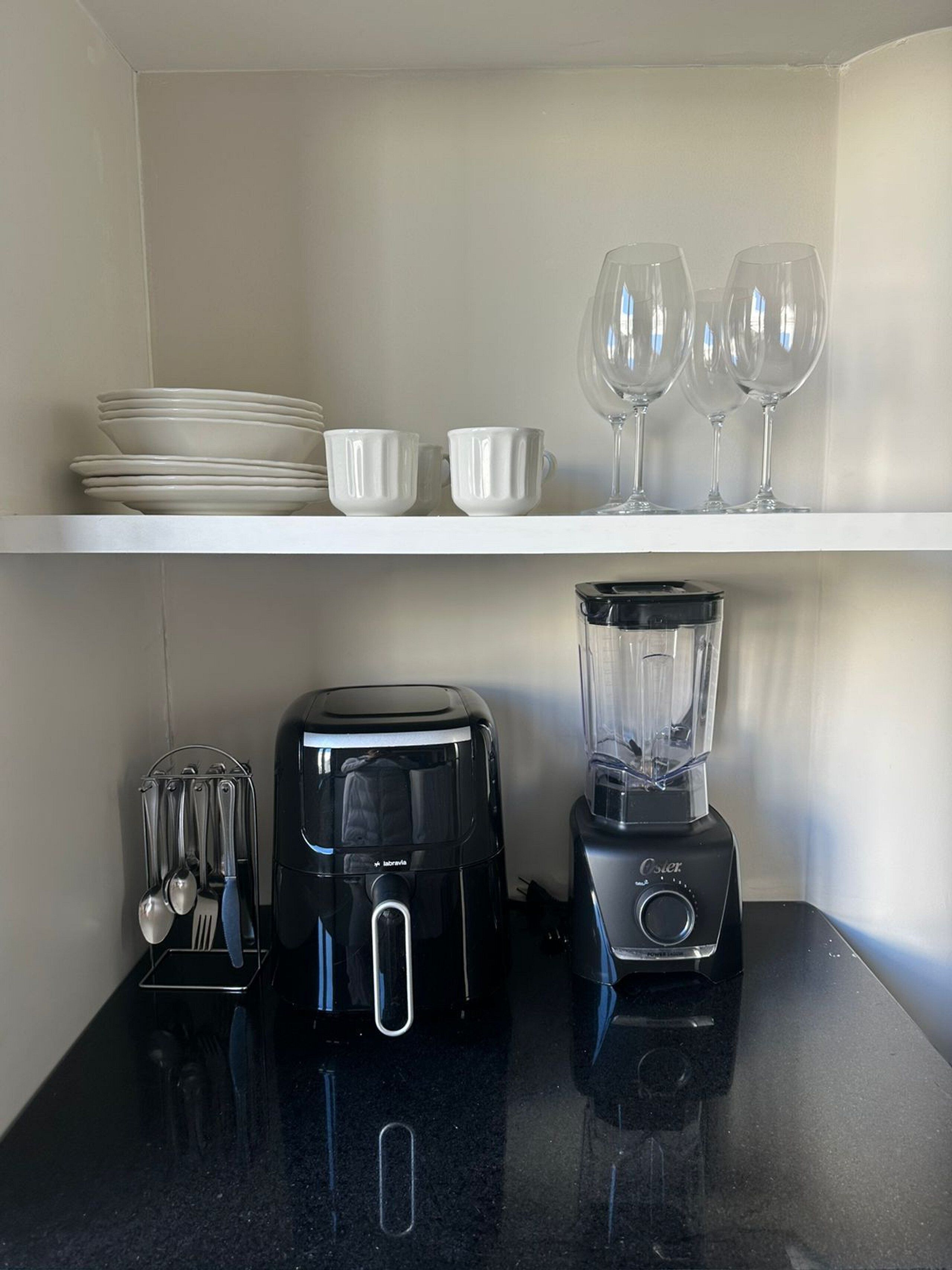 A kitchen with a toaster, a blender, and a utensil holder on the counter.