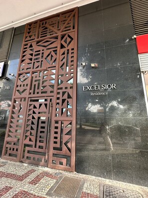 A building facade with a decorative metal gate and a sign reading 'EXCELSIOR Residence.'