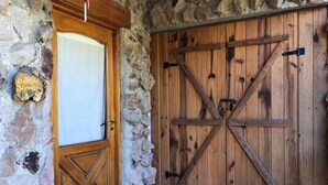 A rustic wooden door with a stone wall and a wooden floor.