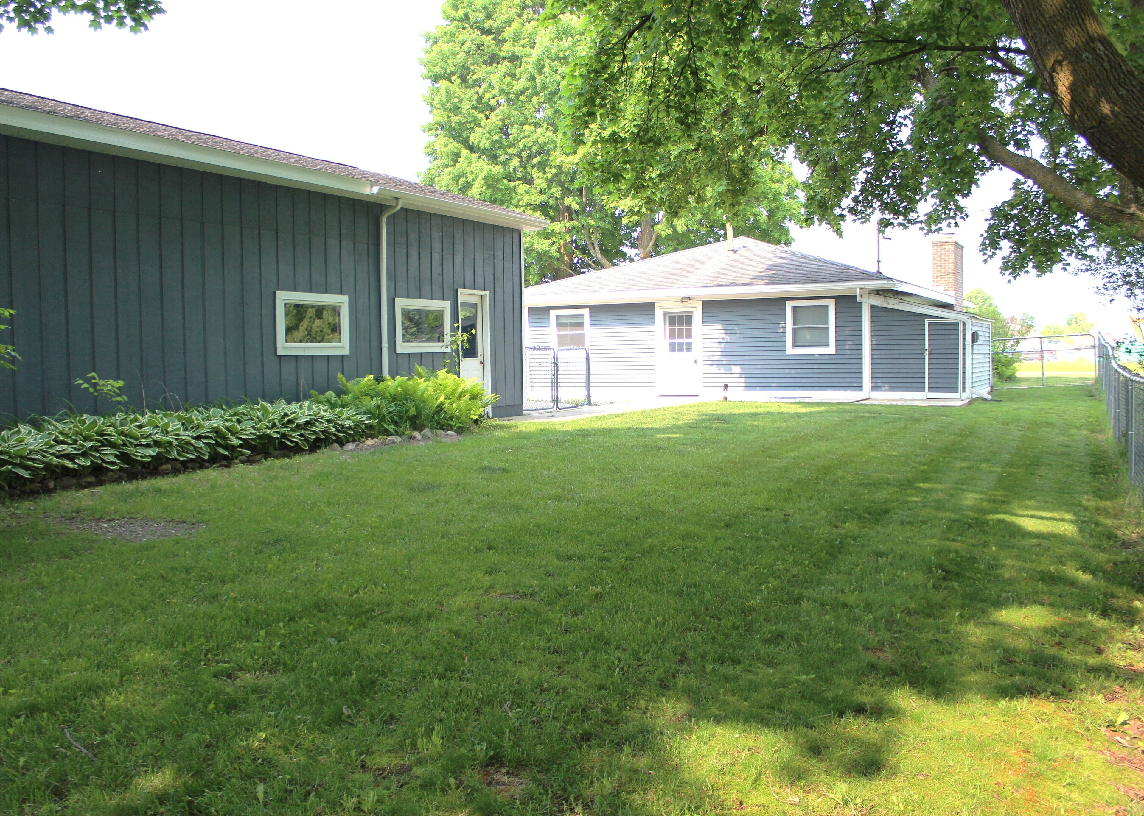 A residential property with a well-maintained lawn, a garage, and a shed.