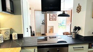 Eine moderne Küche mit schwarzem Arbeitsplatz, Edelstahlgeräten und einem Holzer Schneidebrett.