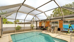 A covered outdoor swimming pool with a patio area, chairs, and a table. - 2 Mi to Riverwalk: Gem w/ Private Pool & Yard! (Bradenton)