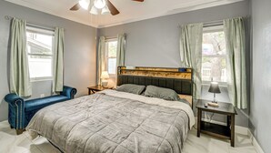 A bedroom with a bed, a nightstand, a lamp, a chair, and a ceiling fan. - 2 Mi to Riverwalk: Gem w/ Private Pool & Yard! (Bradenton)