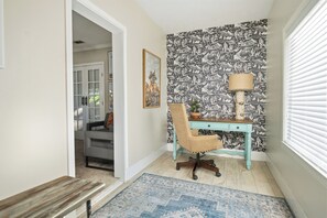 A room with a desk, chair, and a patterned wallpaper. - Hot Tub + Outdoor Kitchen: Stylish Home in Bryan (Bryan)