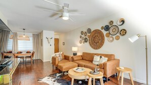 A modern living room with a brown leather sofa, wooden coffee table, and a cowhide rug. - < 1 Mi to Old Town: Scottsdale Condo w/ Balcony (Scottsdale)