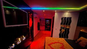 A modern hotel room with a large bed, a TV, and a mirror. - Spicy love romantic suite - private jacuzzi - French Riviera - luxury (Villeneuve-Loubet)