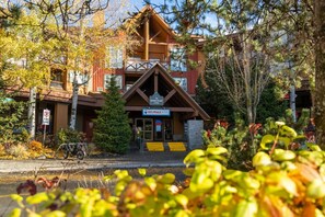 A lodge with a wooden exterior, a sign for RE/MAX, and a 'MARKETPLACE LODGE' sign.