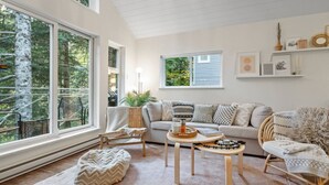 A cozy living room with a large window, a sofa, a coffee table, and a chair. - 2BR Creekside Gem|Steps to Gondola,Free PKNG|Patio (Whistler)