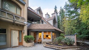 A two-story house with a balcony, a front porch, and a garden area.