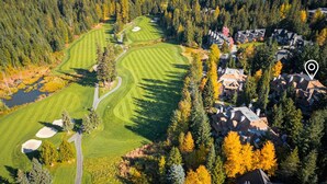 An aerial view of a golf course with a residential area nearby.