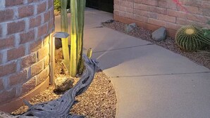 Un bâtiment en briques avec un jardin de cactus et une porte en bois.